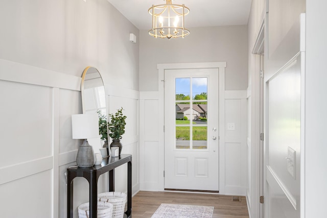 9156 Perry Ct Lot C, Lot C, Zeeland, MI 49464 - entryway featuring a chandelier, light wood-style flooring, a decorative wall, and a wainscoted wall