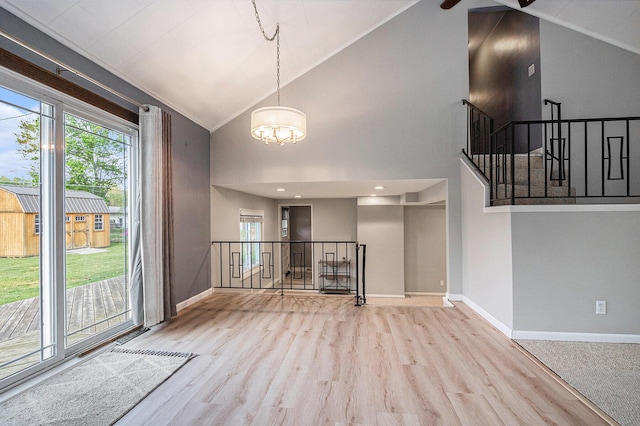 1433 Kingman Dr, Saint Joseph, MI 49085 - unfurnished dining area with a chandelier, baseboards, wood finished floors, high vaulted ceiling, and a ceiling fan