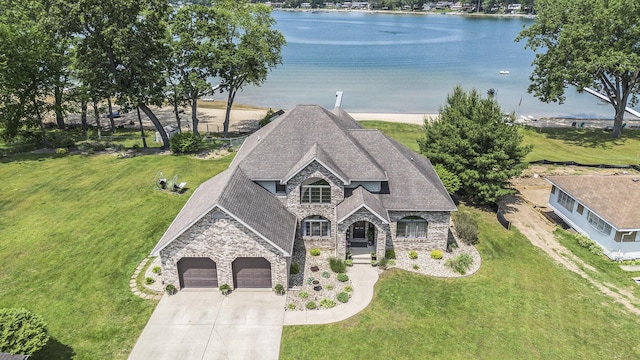 1256 Barron Lake Rd, Niles, MI 49120 - view of front of house featuring stone siding, concrete driveway, a water view, a garage, and a front lawn