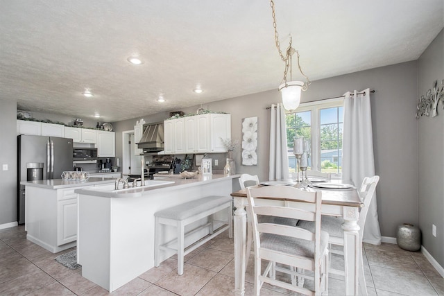 1256 Barron Lake Rd, Niles, MI 49120 - kitchen featuring appliances with stainless steel finishes, white cabinetry, a peninsula, premium range hood, and a kitchen island