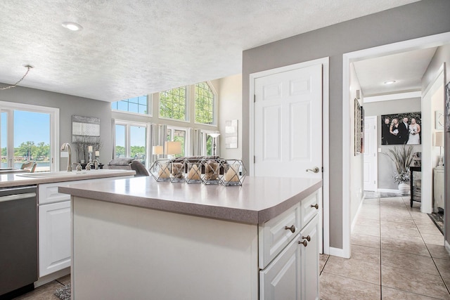1256 Barron Lake Rd, Niles, MI 49120 - kitchen with dishwasher, white cabinets, a kitchen island, open floor plan, and a textured ceiling