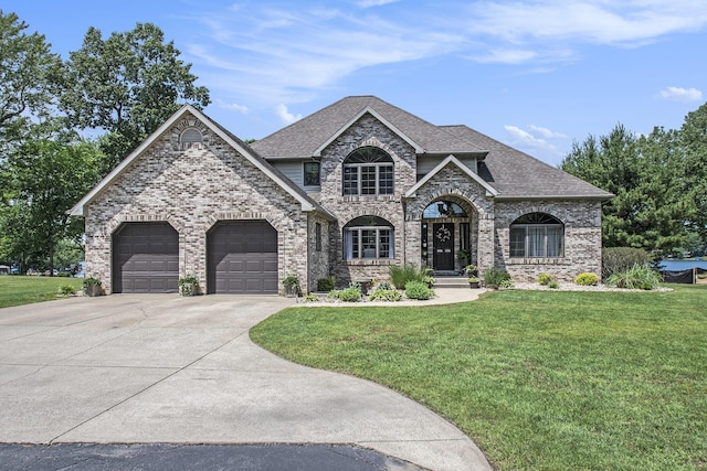 1256 Barron Lake Rd, Niles, MI 49120 - french country home with a front lawn, an attached garage, brick siding, concrete driveway, and a shingled roof