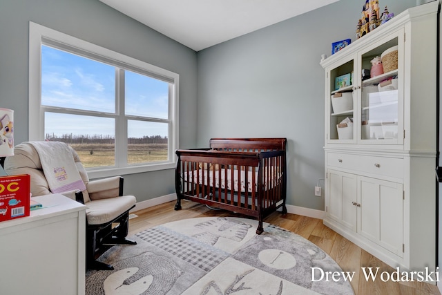 4688 20 Mile Rd, Kent City, MI 49330 - bedroom featuring a crib, baseboards, and light wood finished floors