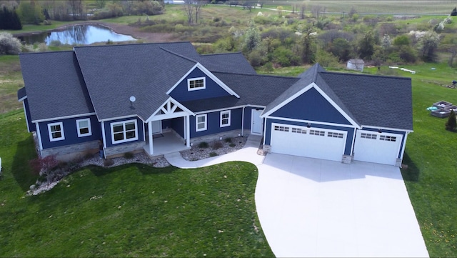 4688 20 Mile Rd, Kent City, MI 49330 - view of front of house featuring an attached garage, concrete driveway, a front lawn, and a water view