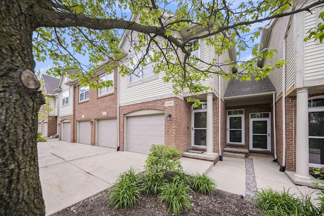 3197 Asher Rd, Ann Arbor, MI 48104 - view of front of home with brick siding, driveway, an attached garage, and roof with shingles