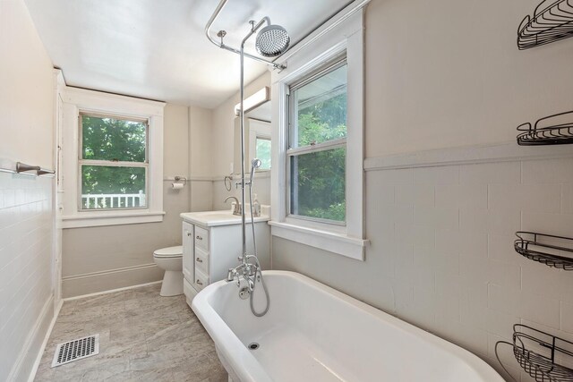 604 Edgewood St, Jackson, MI 49202 - bathroom with toilet, a freestanding bath, vanity, and baseboards