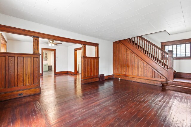 604 Edgewood St, Jackson, MI 49202 - unfurnished living room with stairs, dark wood-type flooring, ceiling fan, and baseboards