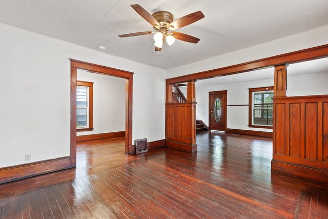 604 Edgewood St, Jackson, MI 49202 - empty room featuring dark wood-type flooring, ceiling fan, stairway, and baseboards