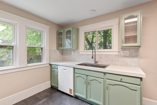 604 Edgewood St, Jackson, MI 49202 - kitchen featuring green cabinetry, a sink, white dishwasher, baseboards, and decorative backsplash