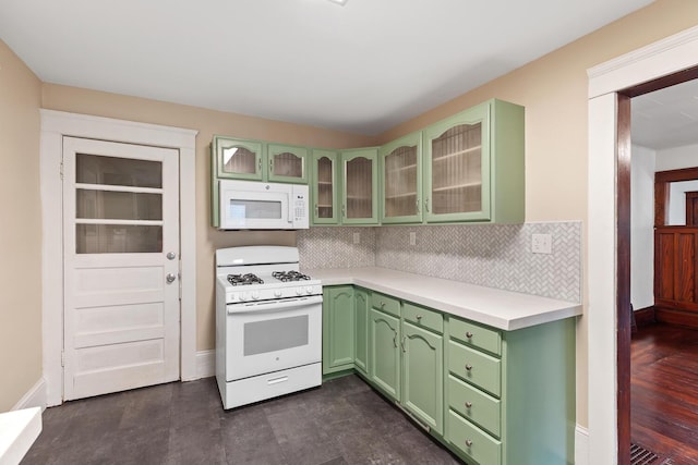 604 Edgewood St, Jackson, MI 49202 - kitchen with white appliances, green cabinetry, light countertops, and tasteful backsplash