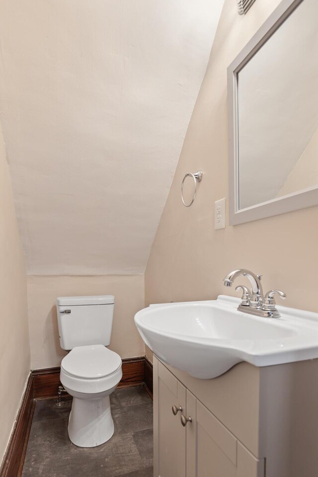 604 Edgewood St, Jackson, MI 49202 - half bathroom with vaulted ceiling, vanity, baseboards, and toilet