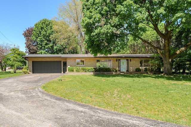 520 N W St, Coloma, MI 49038 - ranch-style house featuring asphalt driveway, a garage, a front yard, and brick siding