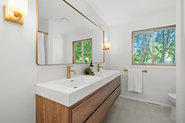 520 N W St, Coloma, MI 49038 - bathroom with double vanity, toilet, baseboards, and tile patterned flooring