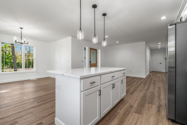 611 River Rd, Marshall, MI 49068 - kitchen featuring freestanding refrigerator, baseboards, wood finished floors, a center island, and white cabinetry