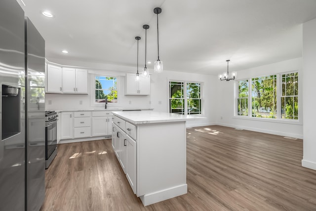 611 River Rd, Marshall, MI 49068 - kitchen featuring stainless steel fridge with ice dispenser, gas stove, baseboards, wood finished floors, and a sink