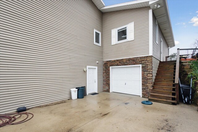 1259 Rose Dr, Niles, MI 49120 - view of home's exterior featuring stairs, an attached garage, stone siding, and concrete driveway