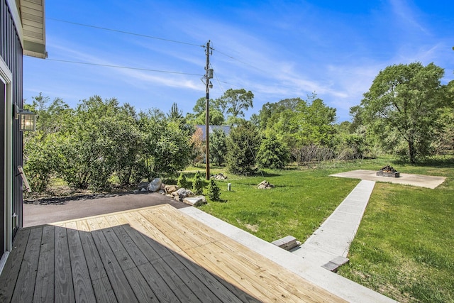 3401 Hicks Ave, Benton Harbor, MI 49022 - deck featuring an outdoor fire pit, a yard, and view of wooded area
