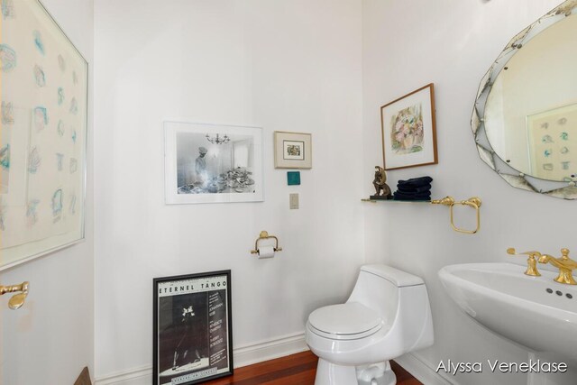 404 N Shore Dr, South Haven, MI 49090 - bathroom with toilet, heating unit, a sink, wood finished floors, and baseboards