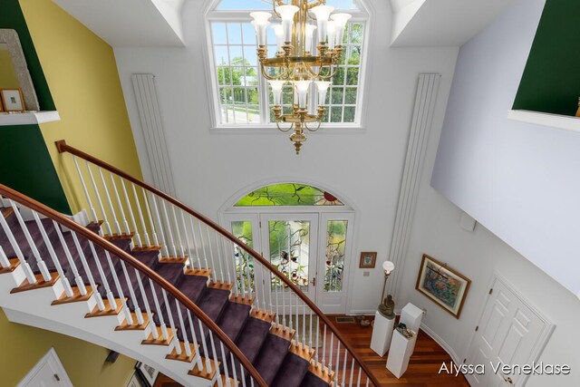 404 N Shore Dr, South Haven, MI 49090 - stairs featuring a chandelier, healthy amount of natural light, wood finished floors, and a high ceiling