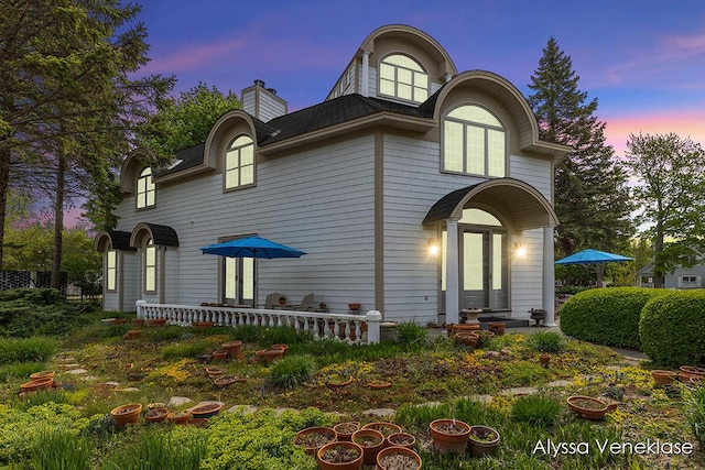 404 N Shore Dr, South Haven, MI 49090 - back of house at dusk with a chimney and a shingled roof
