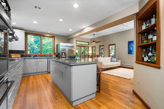 1711 Morton Ave, Ann Arbor, MI 48104 - kitchen featuring stainless steel appliances, a ceiling fan, gray cabinetry, dark countertops, and a kitchen island