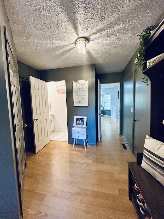 5335 Heathrow Ave, Kalamazoo, MI 49009 - corridor featuring light wood finished floors, baseboards, and a textured ceiling