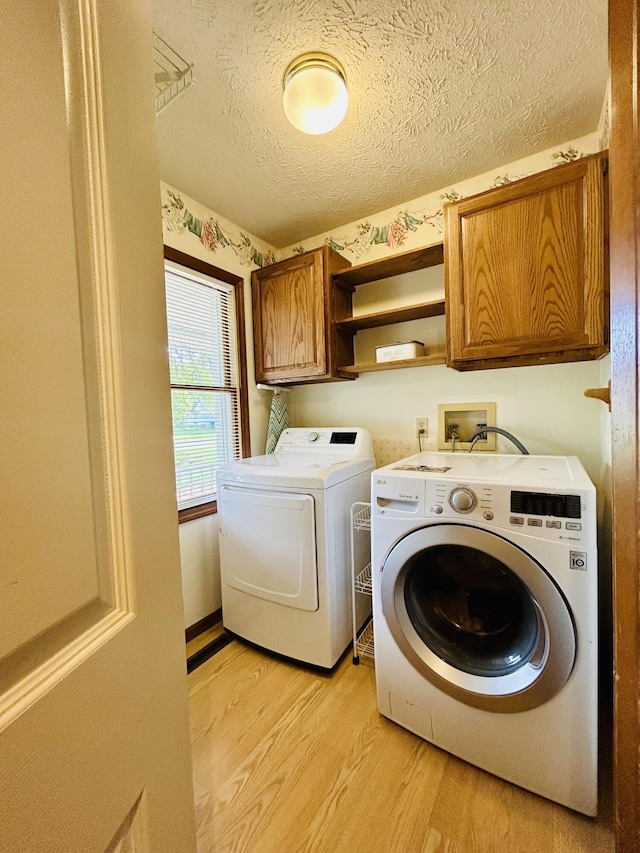 5335 Heathrow Ave, Kalamazoo, MI 49009 - washroom with cabinet space, light wood-style flooring, and washer and dryer
