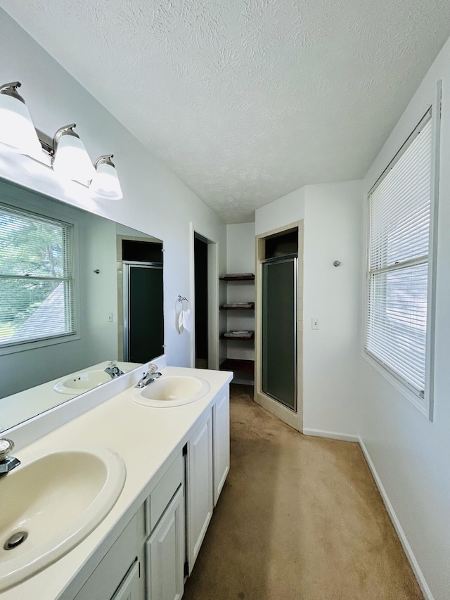 5335 Heathrow Ave, Kalamazoo, MI 49009 - full bathroom with a shower stall, a textured ceiling, double vanity, and baseboards