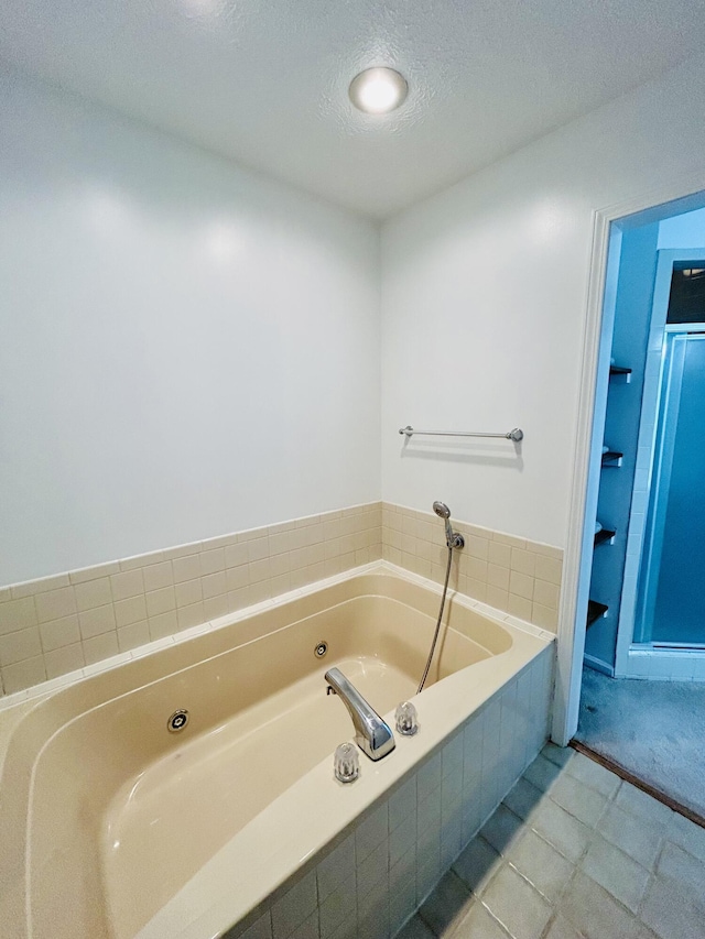 5335 Heathrow Ave, Kalamazoo, MI 49009 - bathroom with a tub with jets, a textured ceiling, and tile patterned floors