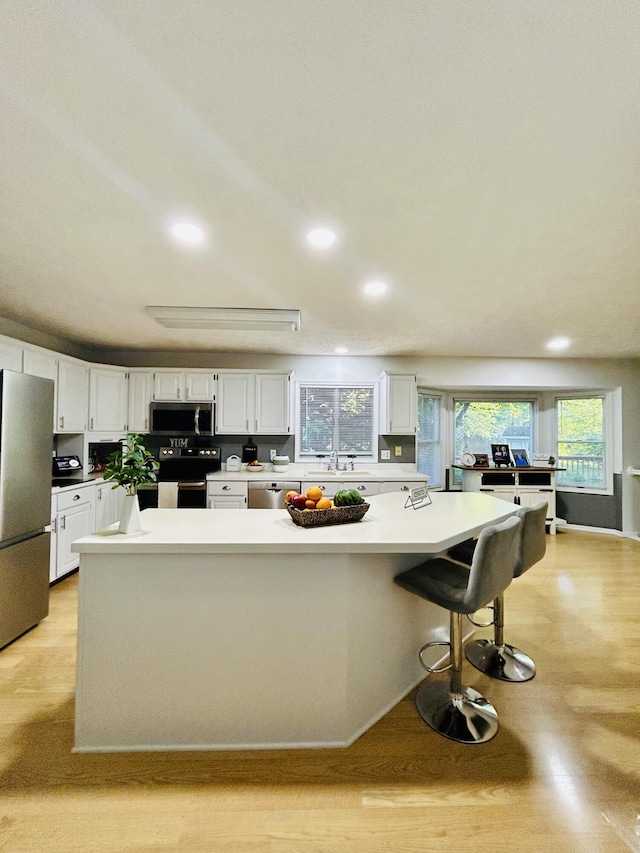 5335 Heathrow Ave, Kalamazoo, MI 49009 - kitchen with appliances with stainless steel finishes, recessed lighting, white cabinetry, a sink, and light wood finished floors