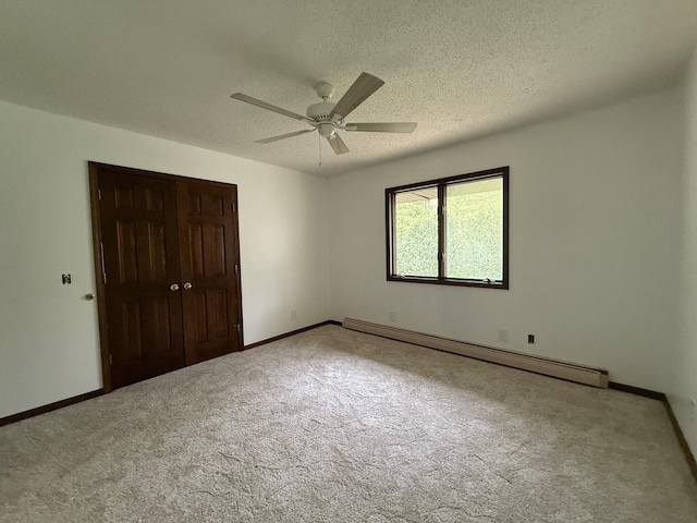 6035 W Trails End Rd, Ludington, MI 49431 - unfurnished bedroom with a baseboard radiator, carpet floors, a closet, a textured ceiling, and baseboards