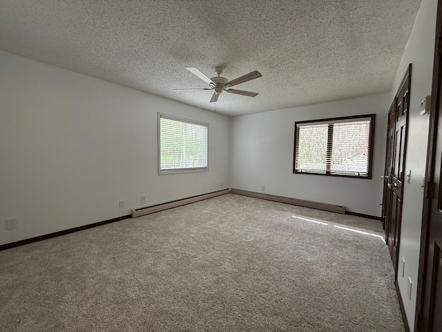 6035 W Trails End Rd, Ludington, MI 49431 - spare room featuring baseboard heating, healthy amount of natural light, a ceiling fan, carpet floors, and a textured ceiling