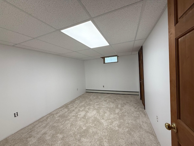 6035 W Trails End Rd, Ludington, MI 49431 - basement featuring a paneled ceiling, carpet, and a baseboard heating unit
