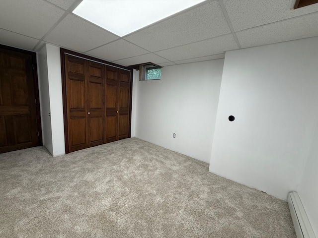 6035 W Trails End Rd, Ludington, MI 49431 - unfurnished bedroom with a paneled ceiling, carpet, a baseboard radiator, and a closet