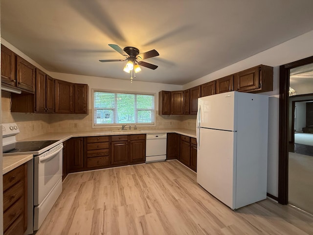 6035 W Trails End Rd, Ludington, MI 49431 - kitchen with white appliances, a sink, ceiling fan, light wood-style flooring, and light countertops