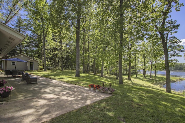 15842 Portage Rd, Vicksburg, MI 49097 - view of grassy yard featuring a patio, a water view, and an outdoor structure