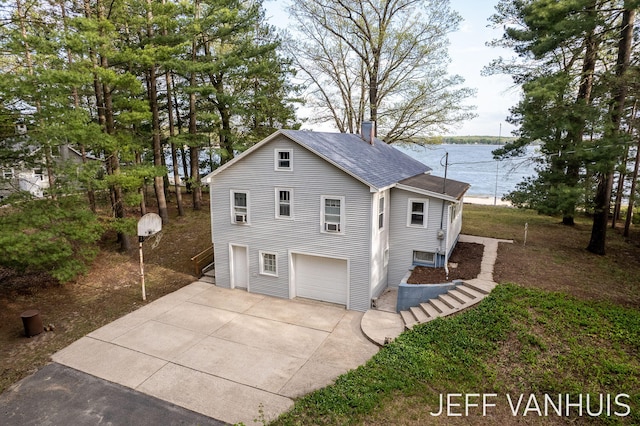 6789 W 76th St, Baldwin, MI 49304 - view of front facade featuring driveway, a shingled roof, a chimney, and an attached garage