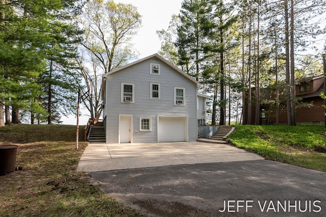 6789 W 76th St, Baldwin, MI 49304 - view of front of property featuring stairway, concrete driveway, and a garage