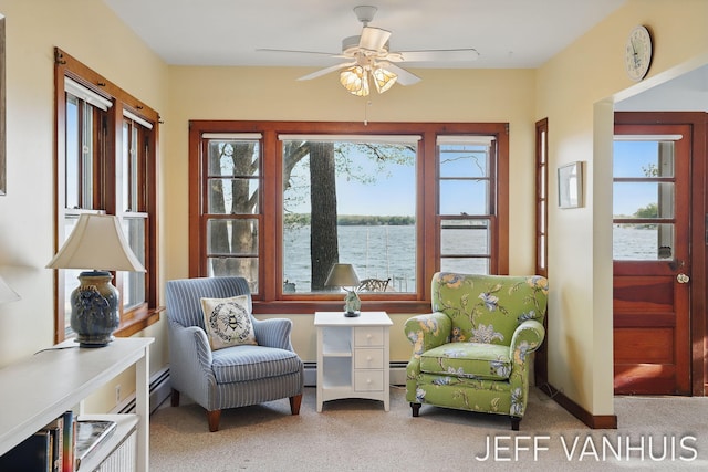 6789 W 76th St, Baldwin, MI 49304 - living area featuring ceiling fan, carpet floors, a water view, and a baseboard radiator