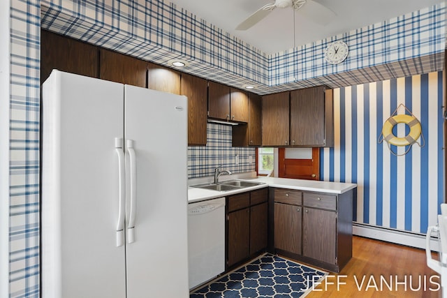 6789 W 76th St, Baldwin, MI 49304 - kitchen featuring white appliances, a sink, wood finished floors, a baseboard heating unit, and light countertops