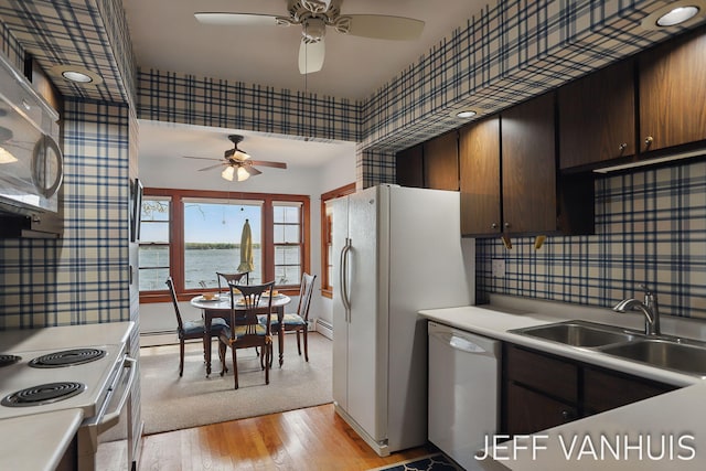 6789 W 76th St, Baldwin, MI 49304 - kitchen with white appliances, a sink, ceiling fan, wallpapered walls, and light countertops
