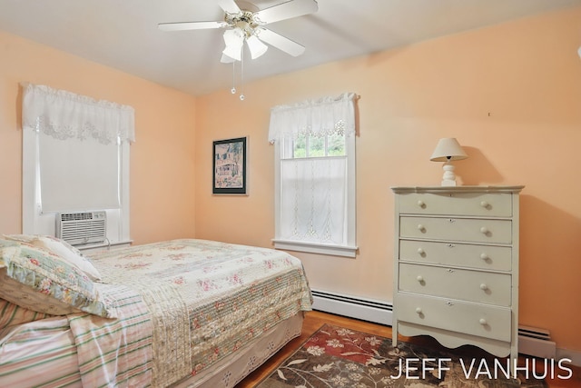 6789 W 76th St, Baldwin, MI 49304 - bedroom featuring baseboard heating, wood finished floors, cooling unit, and ceiling fan