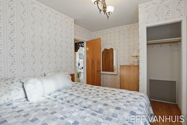 6789 W 76th St, Baldwin, MI 49304 - bedroom with wallpapered walls, a closet, and wood finished floors