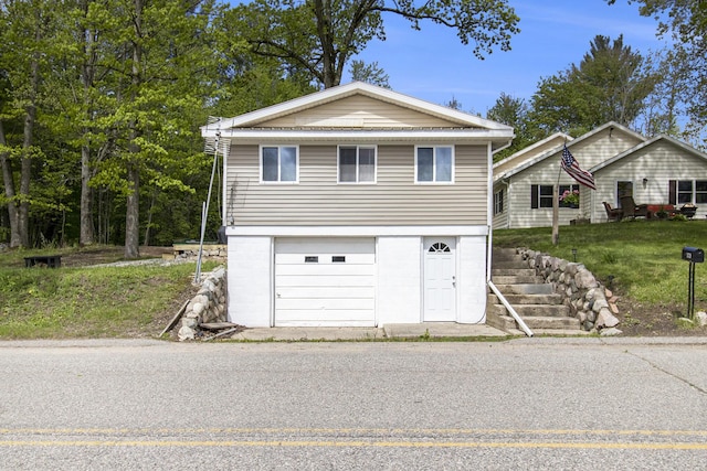 5729 N Bass Lake Rd, Irons, MI 49644 - view of front facade featuring an attached garage and driveway
