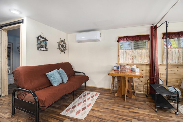 5729 N Bass Lake Rd, Irons, MI 49644 - living area with a wall mounted air conditioner, plenty of natural light, a barn door, and wood finished floors