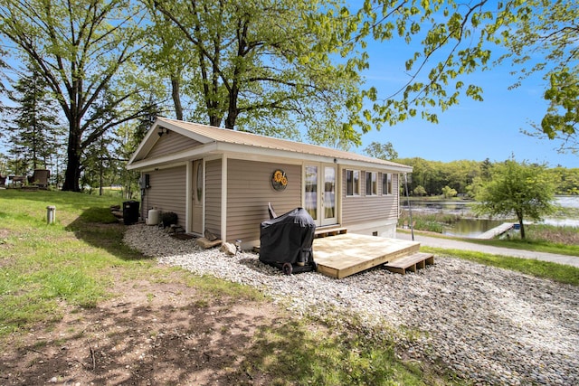 5729 N Bass Lake Rd, Irons, MI 49644 - back of house featuring metal roof, french doors, and a deck with water view