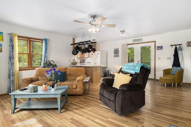 5729 N Bass Lake Rd, Irons, MI 49644 - living room with french doors, healthy amount of natural light, light wood-style floors, and a ceiling fan