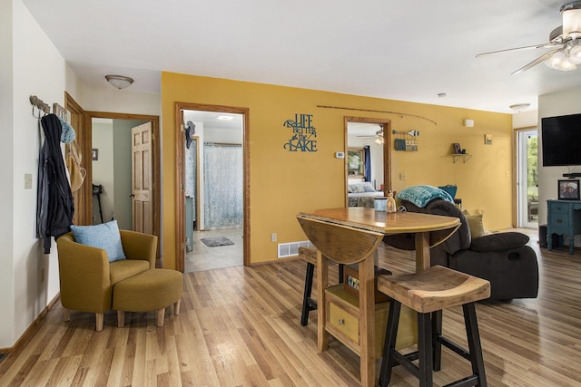 5729 N Bass Lake Rd, Irons, MI 49644 - dining room with ceiling fan, light wood-style floors, and baseboards