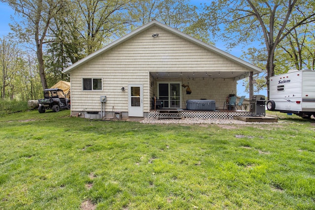 5729 N Bass Lake Rd, Irons, MI 49644 - rear view of house with a hot tub, a wooden deck, and a yard