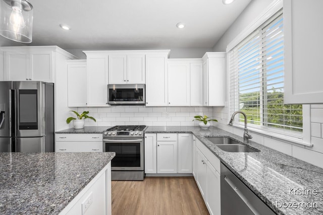 12036 Harvest Home Dr, Lowell, MI 49331 - kitchen with stainless steel appliances, a sink, white cabinets, decorative backsplash, and recessed lighting